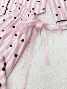 Detail of pink striped heart print pajama set with elegant satin ribbon bow tie.