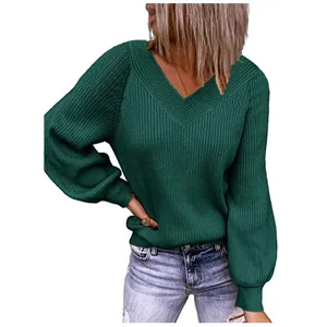 Detail view of a loose dark green knit sweater featuring a stylish V-neck design