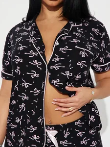 Détail du haut de pyjama noir à manches courtes avec motif nœud rose et col à revers
