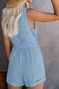 Back view of a light blue sleeveless romper featuring a cinched waist belt and linen texture