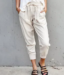 Full view of women's beige linen joggers featuring elastic drawstring waist and cuffs