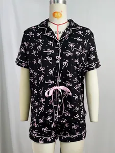 Détail de l'ensemble de pyjama deux pièces avec motif nœud rose sur le tissu noir