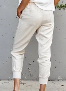 Detailed back view of women's beige cotton-linen jogger pants with elastic waist and cuff