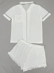 Détail de l'ensemble pyjama blanc à manches courtes avec liseré noir et short à volants
