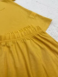 Détail de la taille élastique d'un pantalon de pyjama jaune et texture du tissu