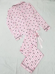 Women's pink and white striped pajama set featuring small heart prints and a satin bow tie
