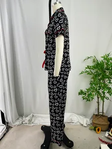 Detailed side view of black heart print pajama set with red piping on white mannequin.