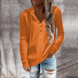 Vista detallada del suéter de punto acanalado naranja con capucha y botones de estilo casual.