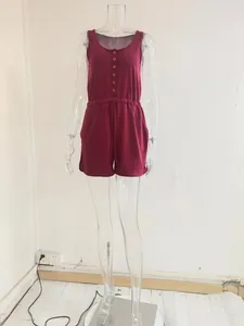 Detailed view showing the drawstring waist and button front of a red sleeveless romper
