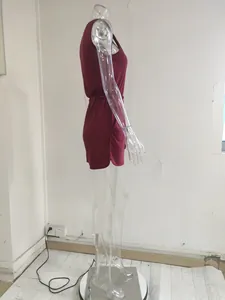 Side view of a sleeveless burgundy romper on a transparent mannequin showing relaxed fit