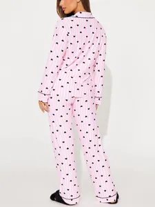 Full back view of women's pink striped two-piece pajama set featuring black heart prints
