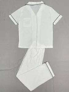Pyjama deux pièces élégant pour femme en blanc avec liseré noir et tissu doux et léger.