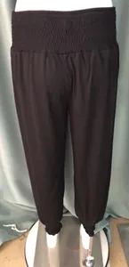 Women's black loose harem pants with high elastic waist and cuffed ankles for yoga fitness