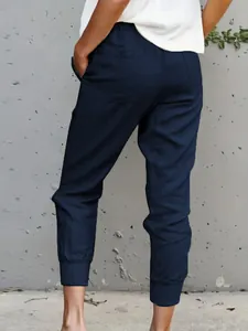 Back view of women's navy blue cotton linen jogger pants featuring a slim fit cut
