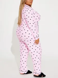Side view of women's pink striped pajama set with black heart prints and lapel collar
