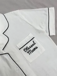 Gros plan sur le haut de pyjama blanc avec broderie Blessed Mama sur la poche poitrine