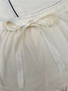 Détail rapproché du short de pyjama crème avec taille élastique et nœud en ruban satiné