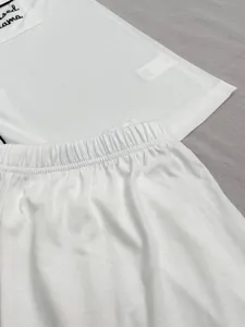 Détail d'un ensemble de pyjama blanc deux pièces montrant la texture et la taille.