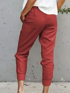 Back view detail of red cotton linen joggers showing slimming fit and cuffed ankles