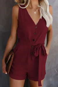 Detail of burgundy V-neck romper with button front and adjustable bow belt.