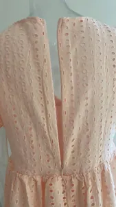 Dettaglio della cerniera invisibile sul retro di un abito in pizzo color pesca.