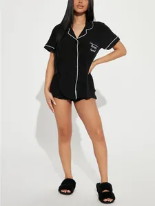 Ensemble de pyjama noir femme à manches courtes avec passepoil blanc et détail de poche.