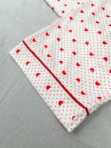 Close-up of soft pajama cuff featuring red heart and polka dot print with piping