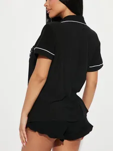 Vue arrière d'un ensemble de pyjama noir pour femme avec liseré blanc et short à volants