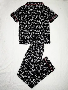 Women's two-piece pajama set with black and white heart print and red piping detail