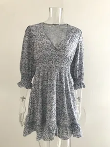 Bohemian floral print V-neck dress with smocked waist and ruffled cuffs on mannequin display