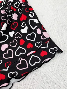 Close-up detail of women's heart print pajama shorts featuring a cute lettuce hem
