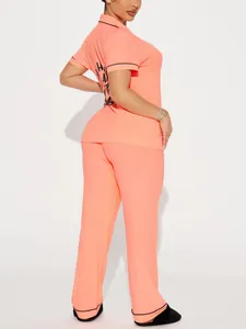 Two-piece coral short sleeve pajama set with black trim and back graphic detail