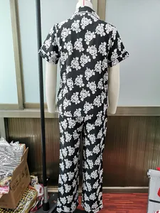 Back view of women's black floral print pajama set with short sleeves and pants.