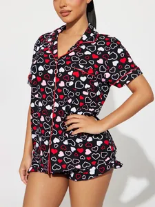 Close-up of a women's short-sleeved pajama set with red heart print and piping detail.