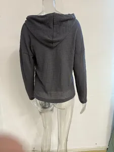Detailed back view of a charcoal grey waffle-knit hooded jacket on a clear mannequin