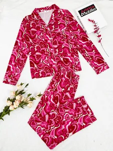 Detail view of pink psychedelic heart print pajamas with notched collar and white piping