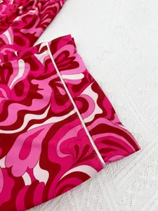 Detailed view of vibrant pink swirly print pajama sleeve cuff with white piping trim