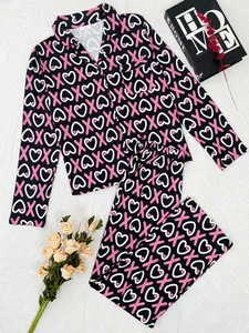 Two-piece women's pajama set featuring heart and XOXO print on black fabric detail