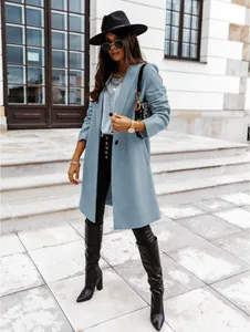 Stylish light blue mid-length wool coat worn by a model in an urban outdoor setting.