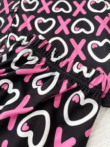 Detailed view of women's soft pajama pants with pink heart print and elastic waistband