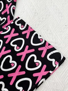 Close-up of soft printed nightwear fabric with pink hearts and XOXO pattern