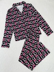 Detailed view of women's long-sleeve pajama set with pink heart and X print patterns