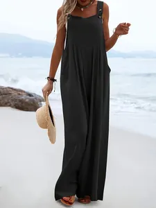 Vue en pied d'une combinaison noire sans manches à jambes larges sur une plage ensoleillée