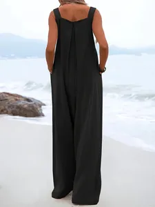 Vue arrière d'une combinaison noire chic sans manches avec jambes larges sur la plage