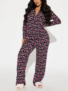 Women's two-piece pajama set with pink X and white heart print on black fabric