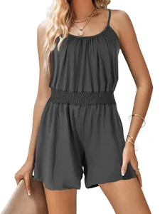 Close-up detail of a dark grey summer spaghetti strap romper with a smocked waist on model