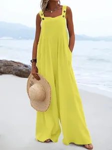 Combinaison sans manches jaune vif à jambes larges avec boutons sur une plage ensoleillée