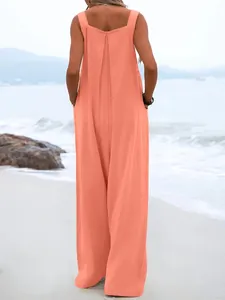Vue arrière d'une combinaison sans manches corail à jambes larges pour femme sur la plage