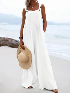Combinaison d'été blanche à jambes larges avec bretelles boutonnées prise sur une plage
