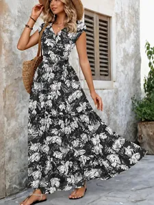 Detail view of a black and white leaf print maxi dress with a V-neckline and short sleeves.